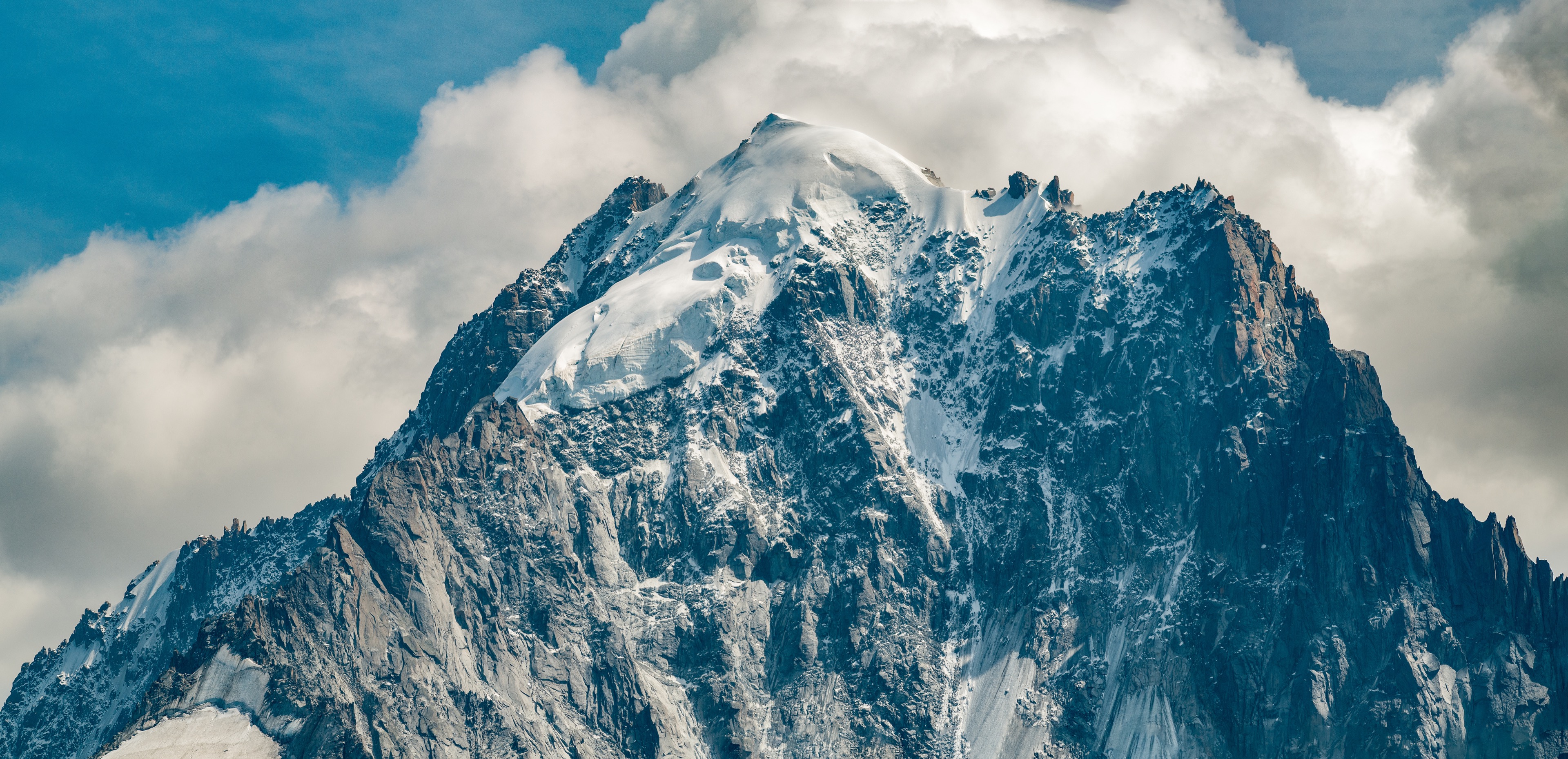 Snow-capped mountain peak against a dramatic sky